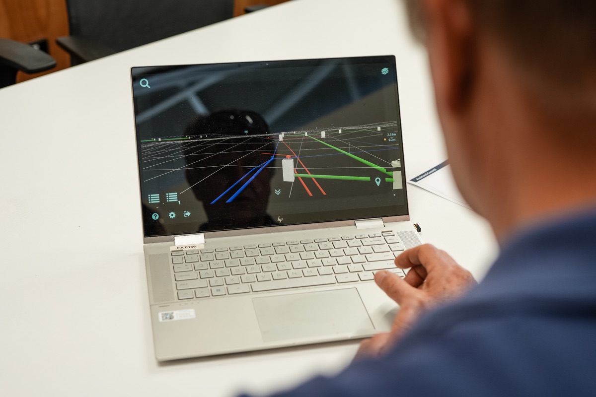 Person viewing coloured service lines and modelled assets on a laptop in Augview.